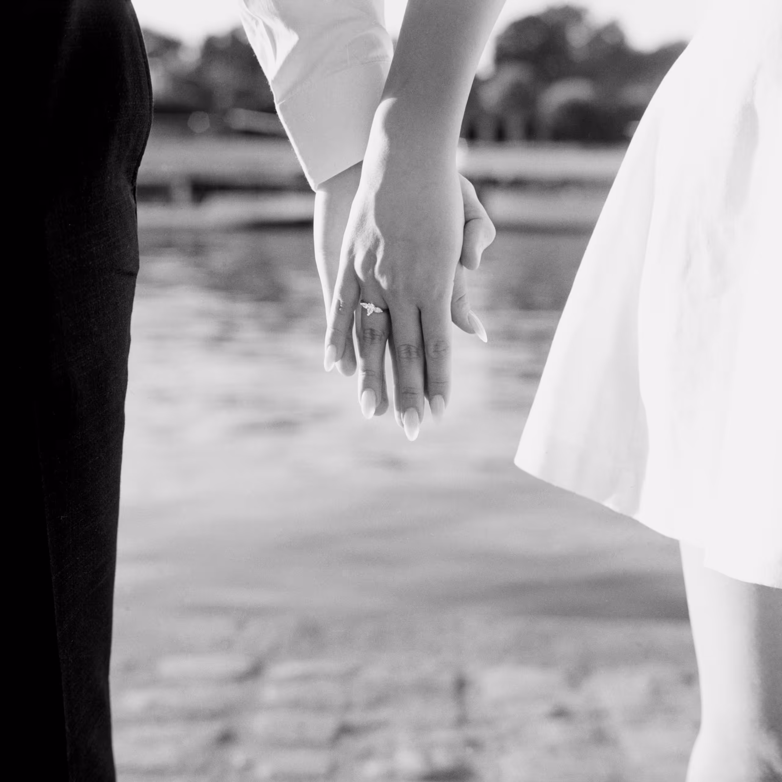 Couple's joined hands and engagement ring above the Paris cobbles