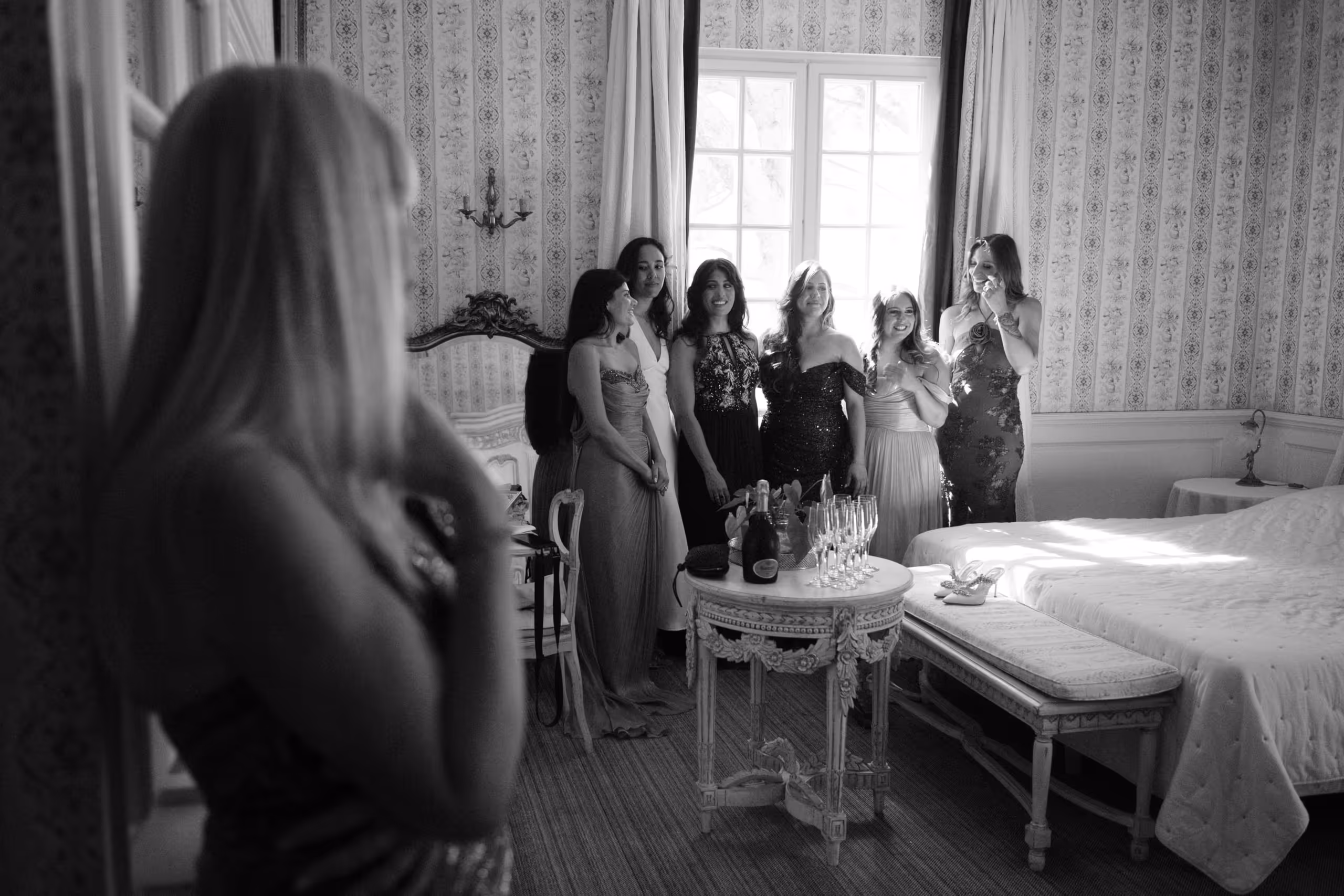 Bridesmaids gathered with champagne in the window light of a chateau bedroom, bastide d'astres, provence wedding, south of france