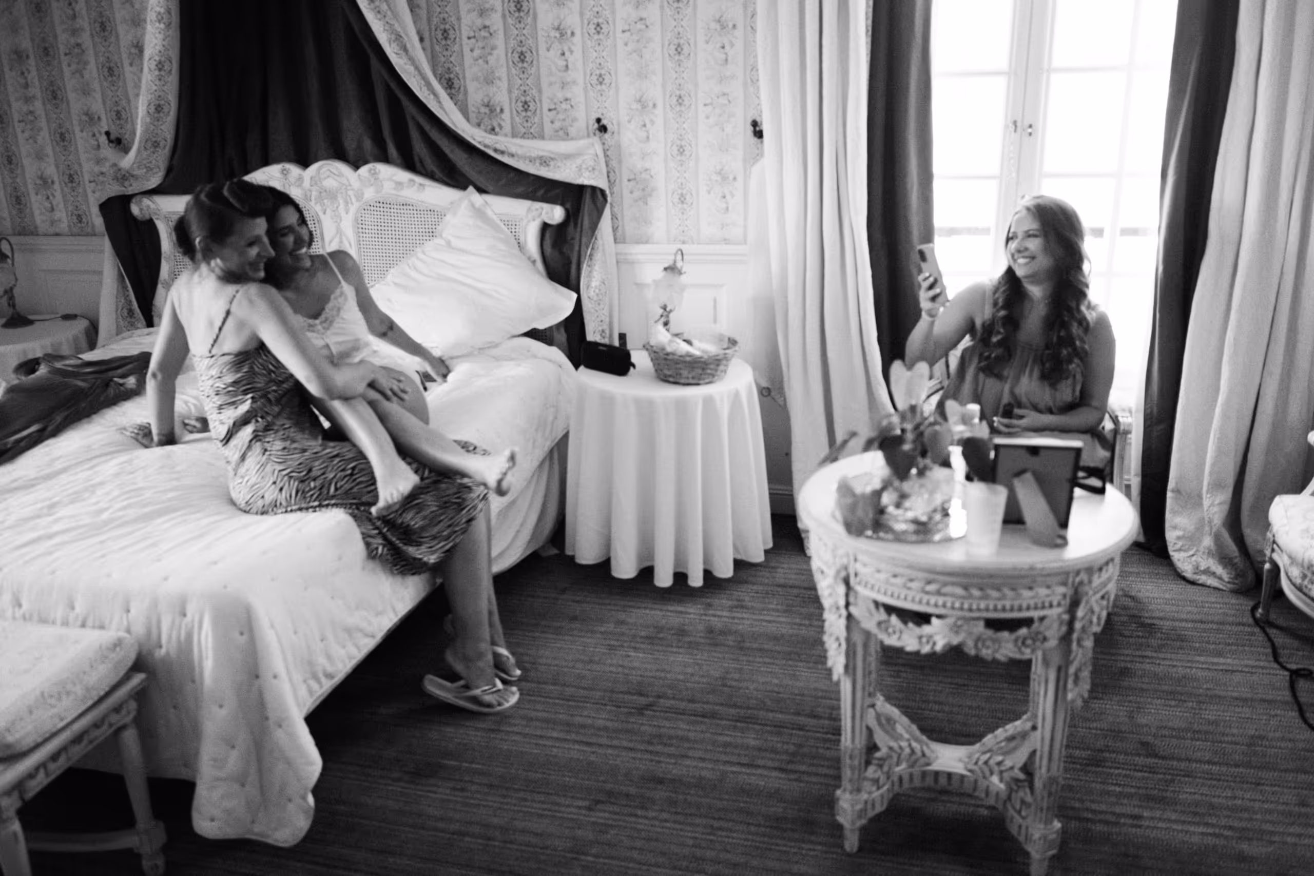Bridesmaids getting ready together on the bed of a chateau bedroom, bastide d'astres, provence wedding, south of france