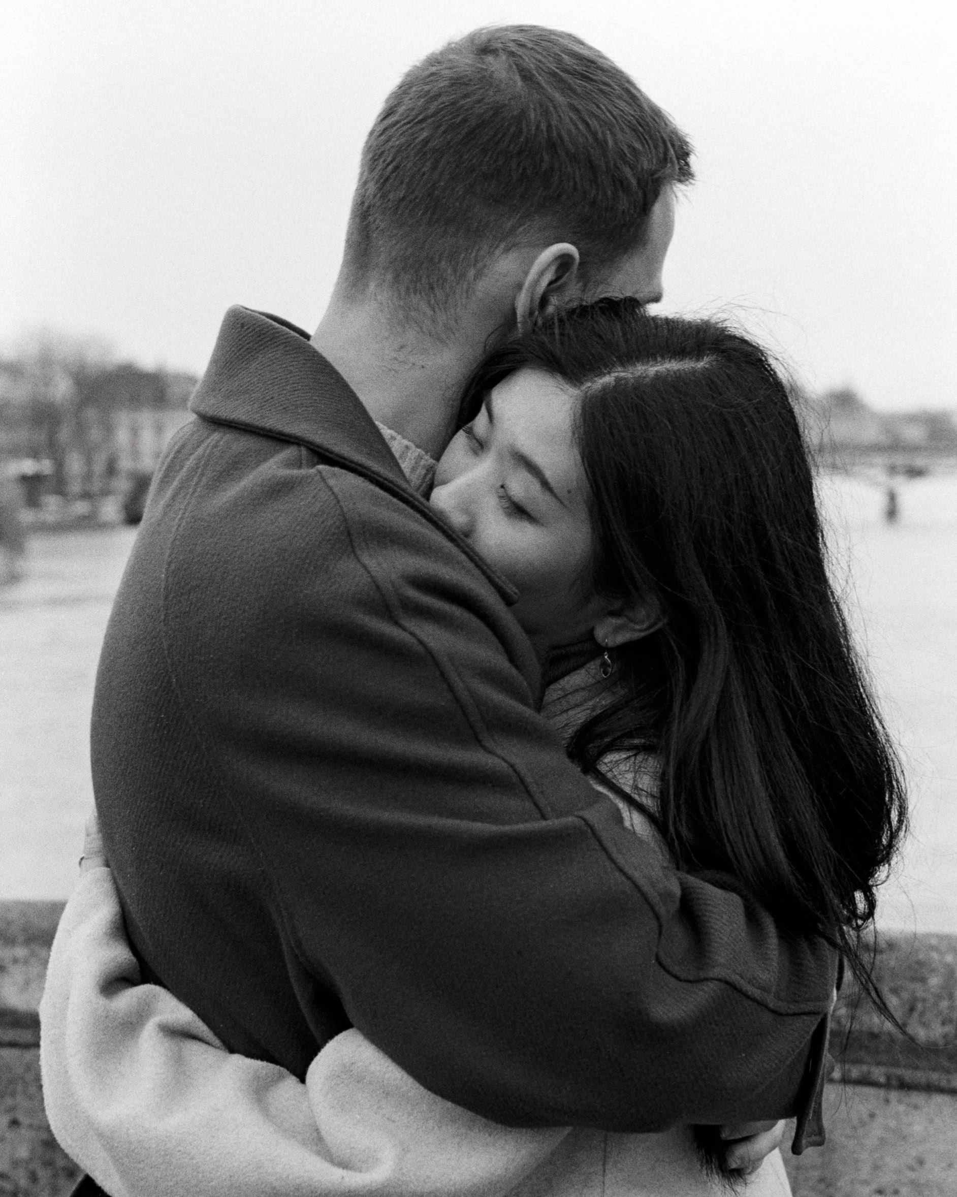 'Couple embracing on the Quais de Seine, shot on black and white film, paris, engagement session, couple session, film photography