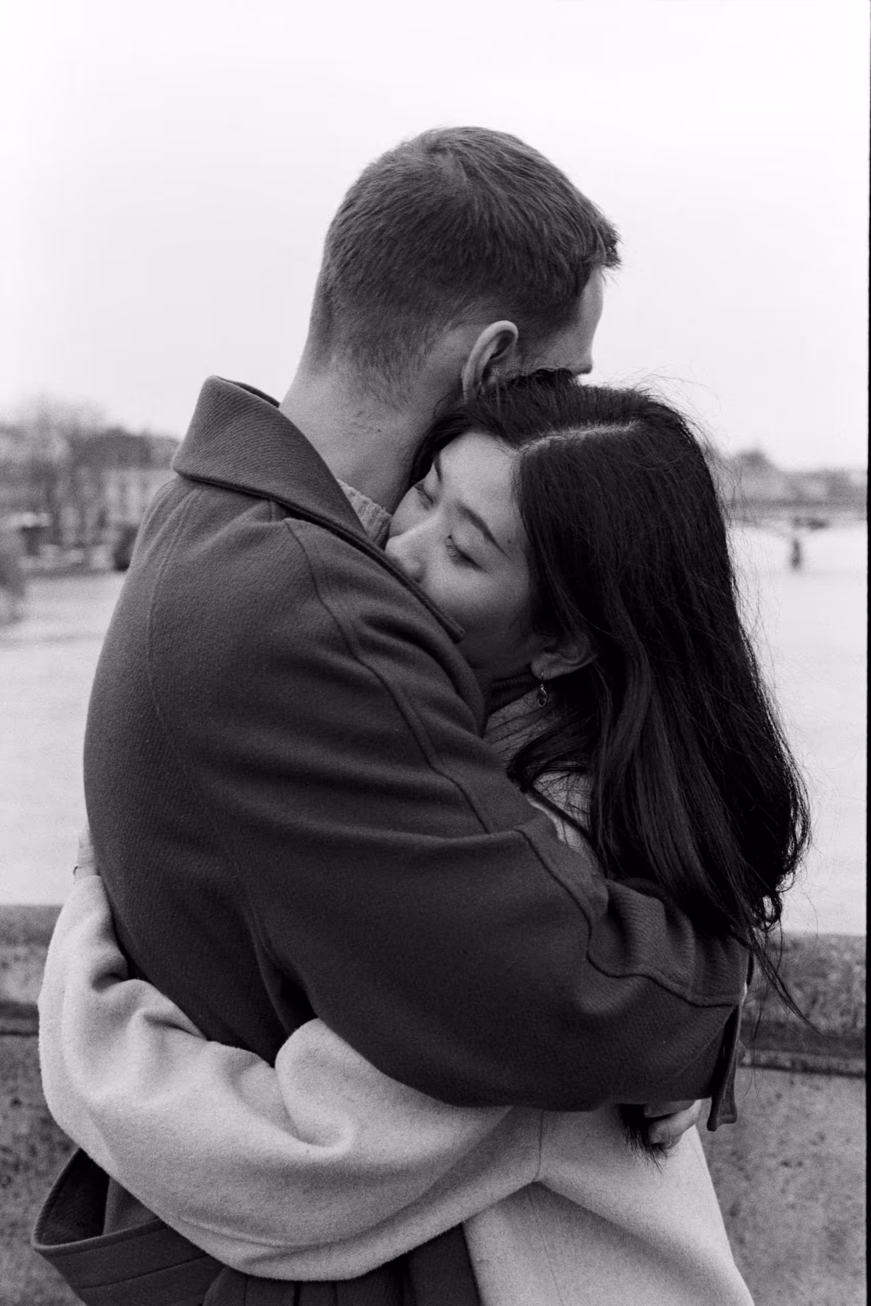 Couple embracing on the Quais de Seine in winter, shot on black and white film