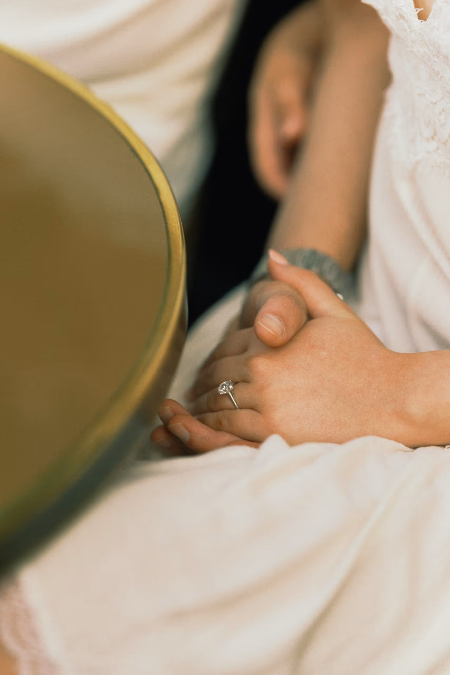 Close detail of a couple's joined hands and her engagement ring, Paris couple session