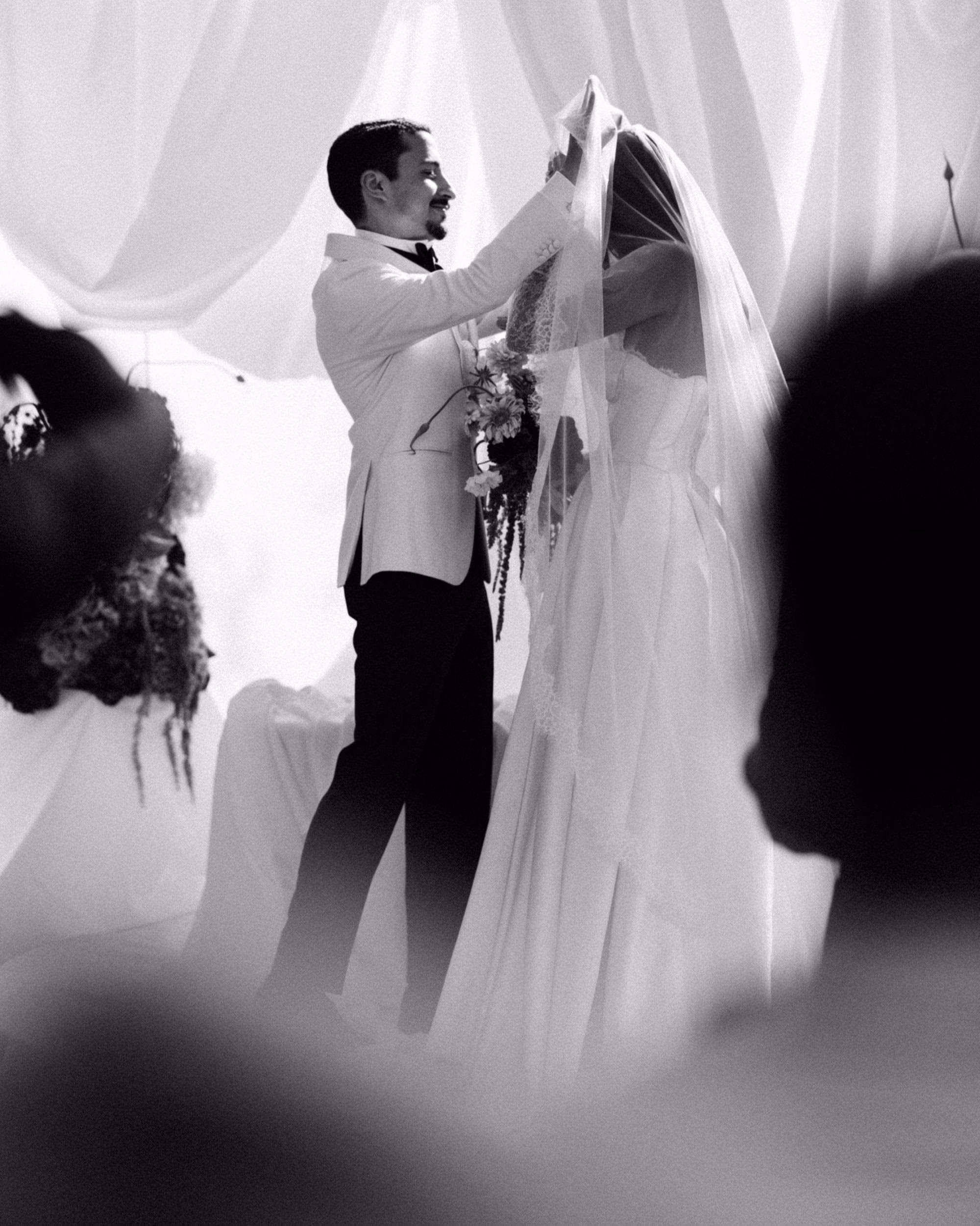 groom lifting brides veil during their wedding ceremony, flower bouquet, south of france, provence, bastide d'astres