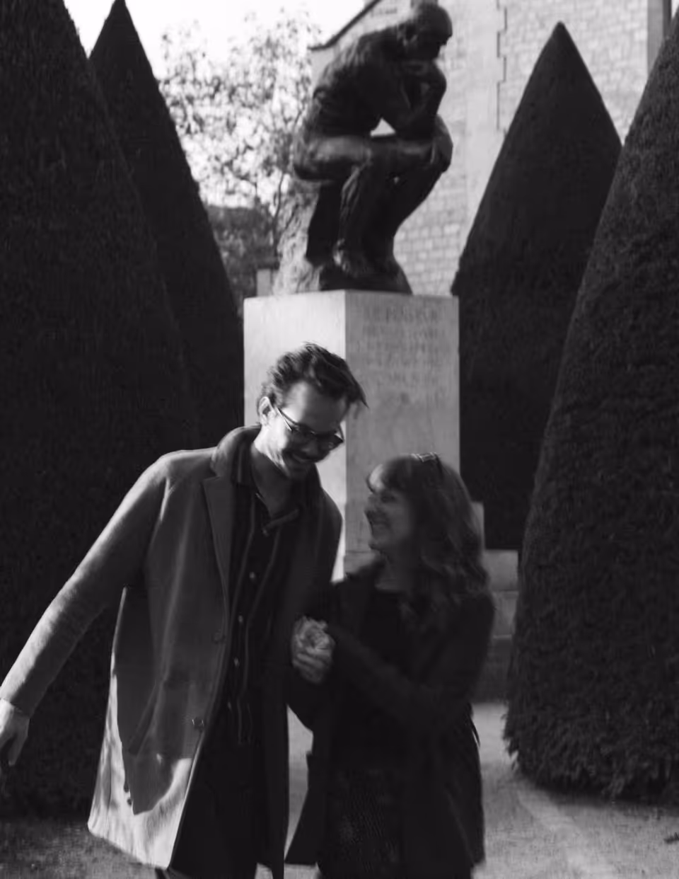Black-and-white photograph of Paige and Reinhardt walking arm in arm through the Musée Rodin garden.